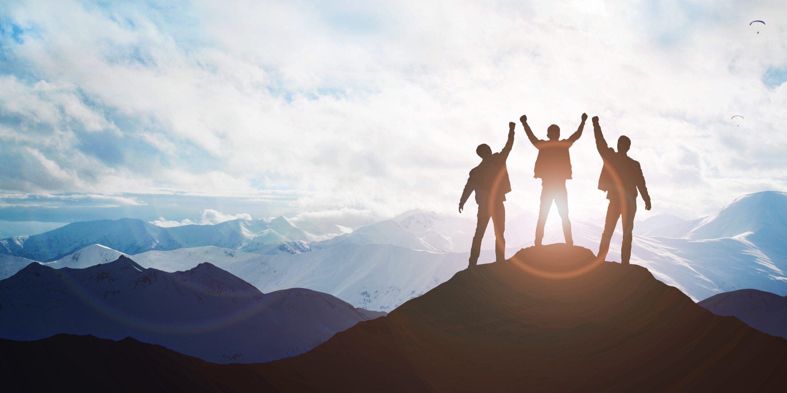 Silhouette of the team on the peak of mountain